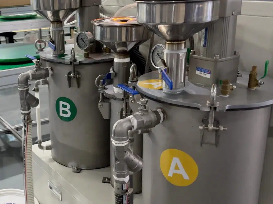 Dual-component resin coating tanks labeled A and B used in Ikonmac’s protective encapsulation process