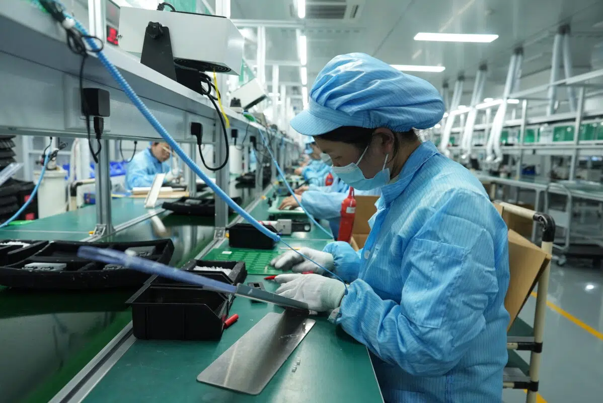 Ikonmac factory worker assembling components on the production line in a cleanroom environment
