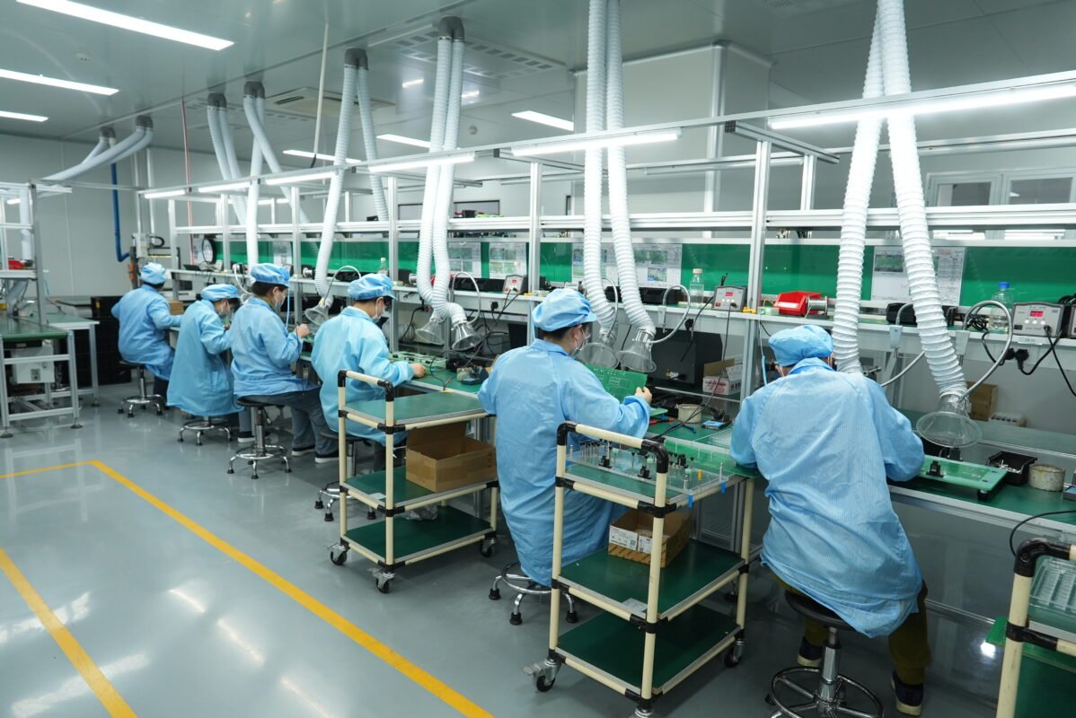 Ikonmac technicians assembling and testing circuit boards in a cleanroom production facility
